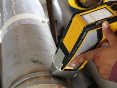 Handheld PMI analyser testing a stainless steel pipe